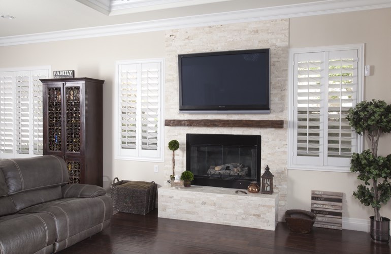 White plantation shutters in a Minneapolis living room with plank hardwood floors.